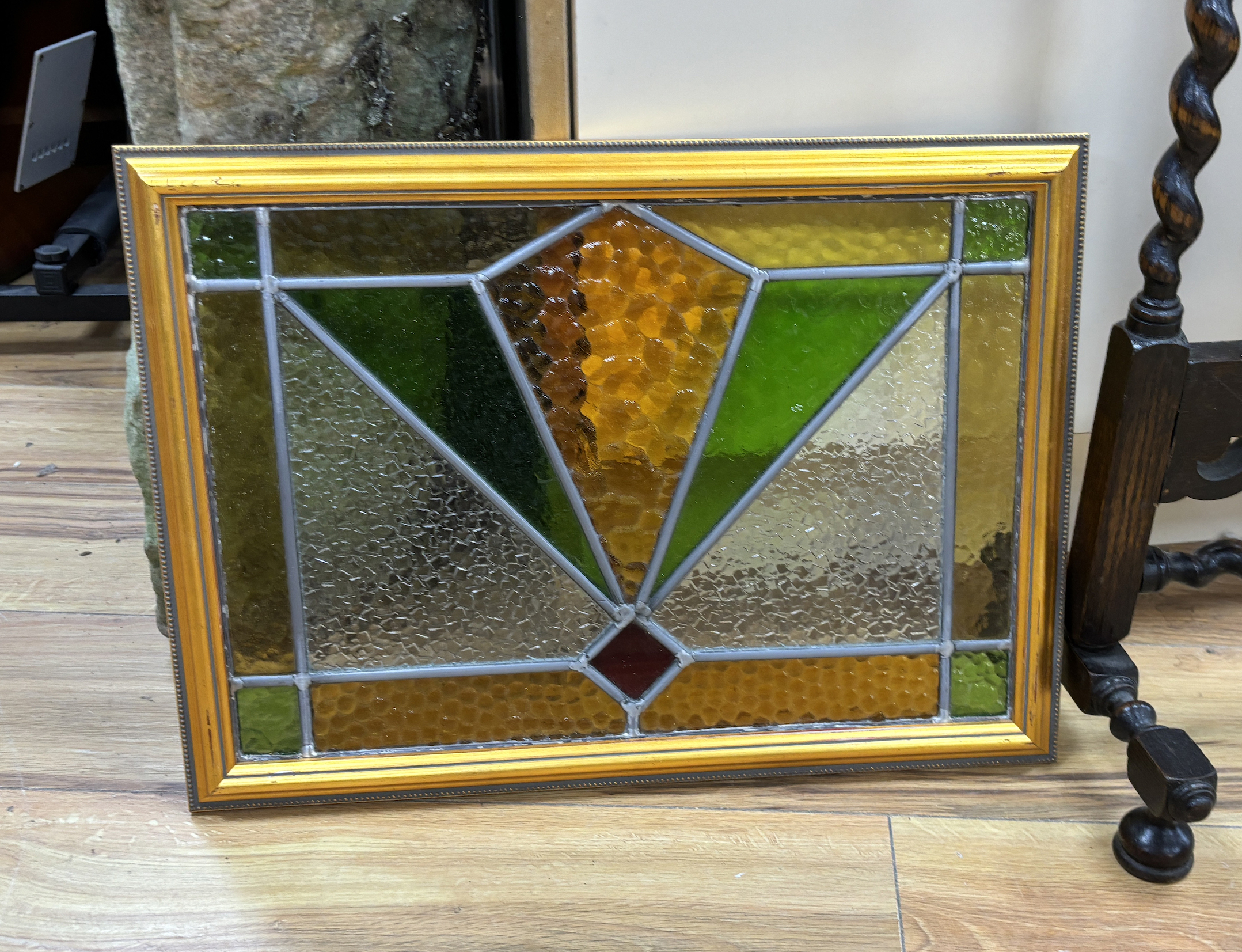 An early 20th century stained glass oak firescreen, height 84cm together with a pair of Art Deco style stained glass panels